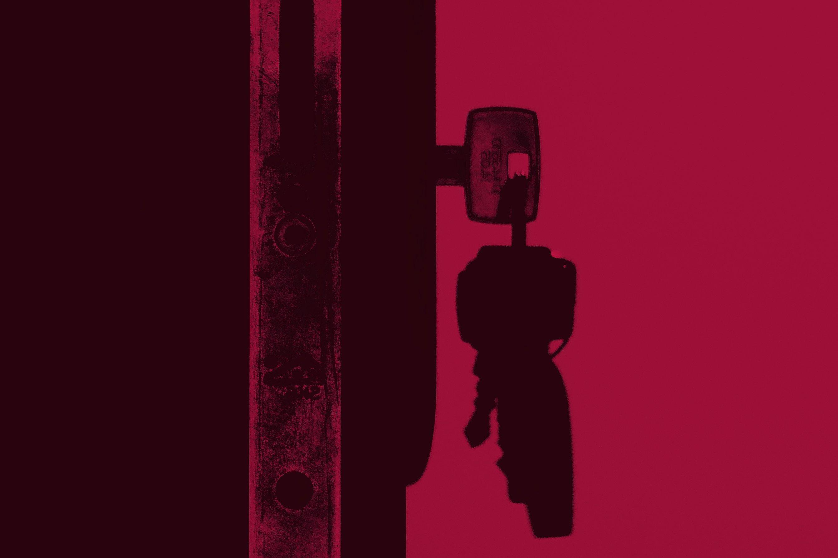 Schlüsselbund steckt in einem Türschloss, Profilaufnahme, schwarz | rot